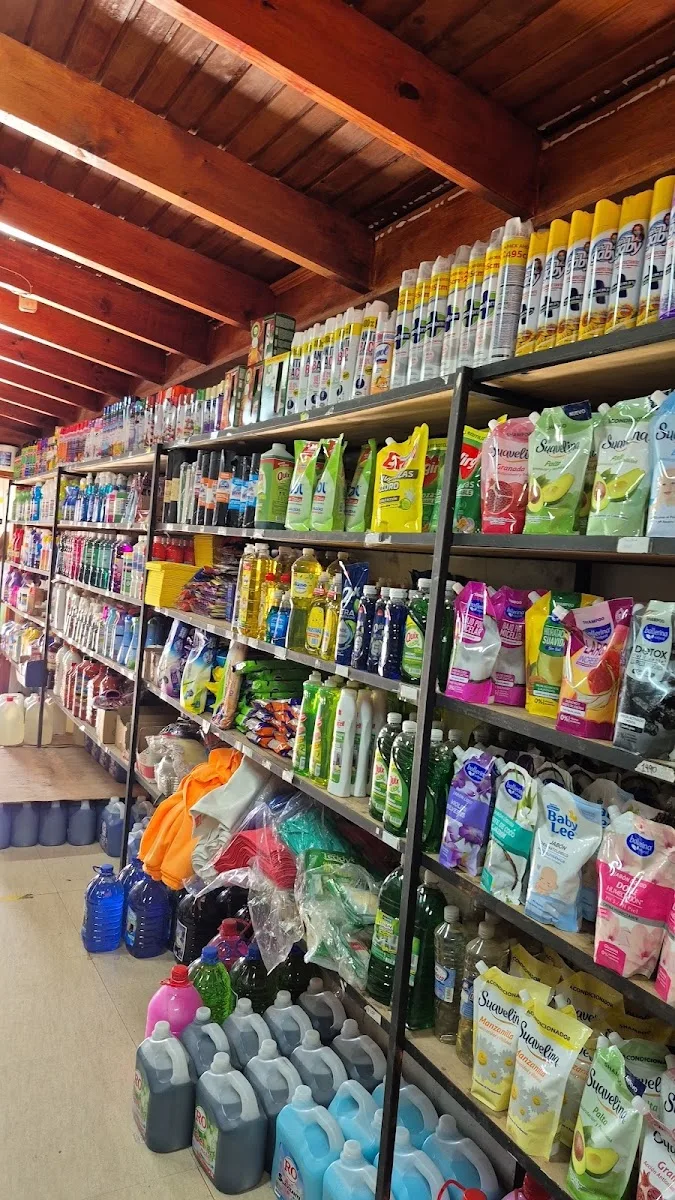 Pasillo central de Comercializadora A y L en Talca: estantes llenos de productos de aseo hasta el techo de madera