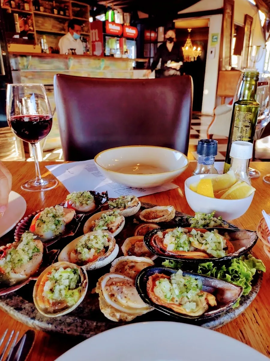 Machas a la parmesana servidas en la mesa de Donde Jaqueline, con vino