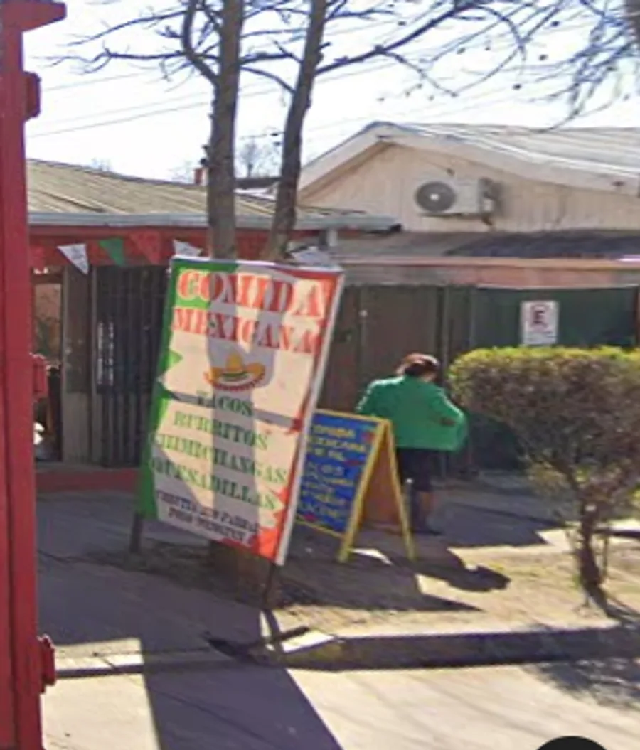 Letrero en la vereda de Comida Rápida Mexicana con banderines tricolor, en calle Urrutia, Parral