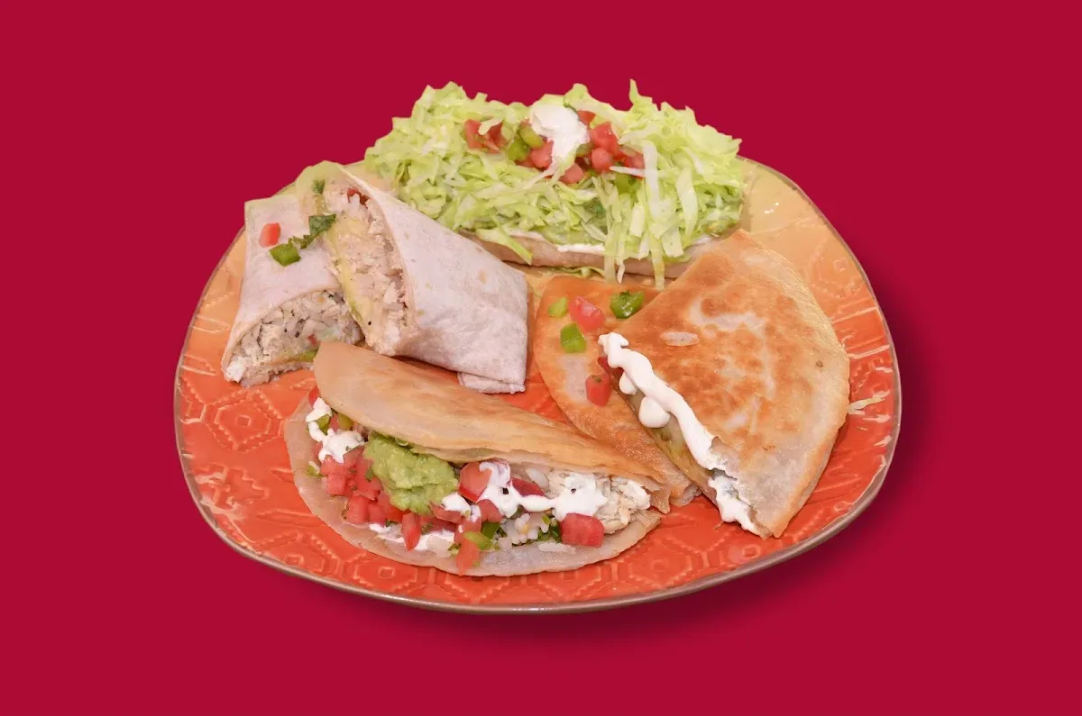 Tacos servidos en plato rojo con ensalada fresca