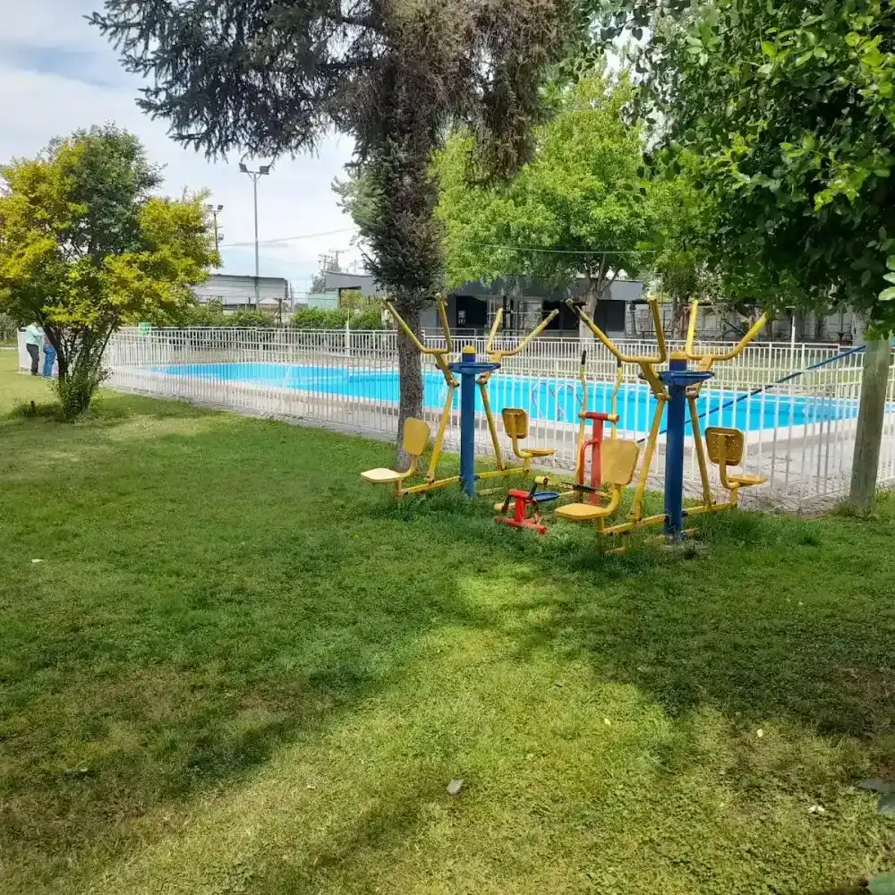 Máquinas de ejercicio al aire libre junto a la piscina