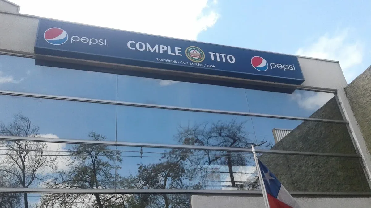 Letrero navy de Comple-Tito Sandwichs Café Express Shop con logos Pepsi, sobre la fachada vidriada