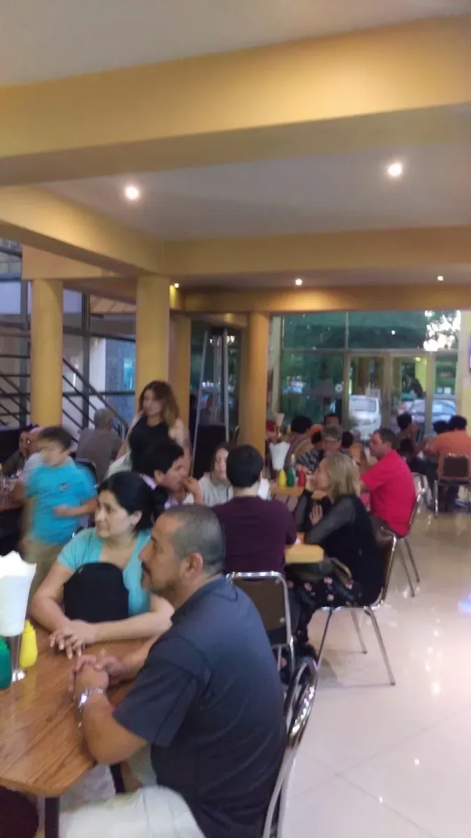 Salón interior lleno de gente almorzando en Comple-Tito
