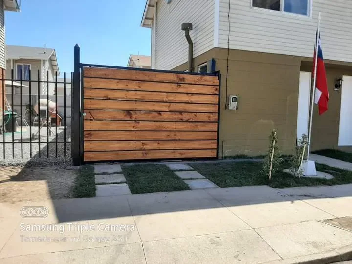 Portalón corredero de madera instalado al frente de una casa