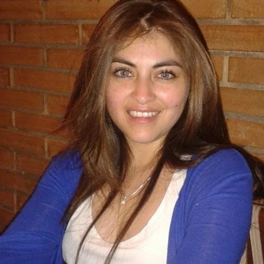 Jacqueline Moraga, contador auditor, sonriendo frente a un muro de ladrillo