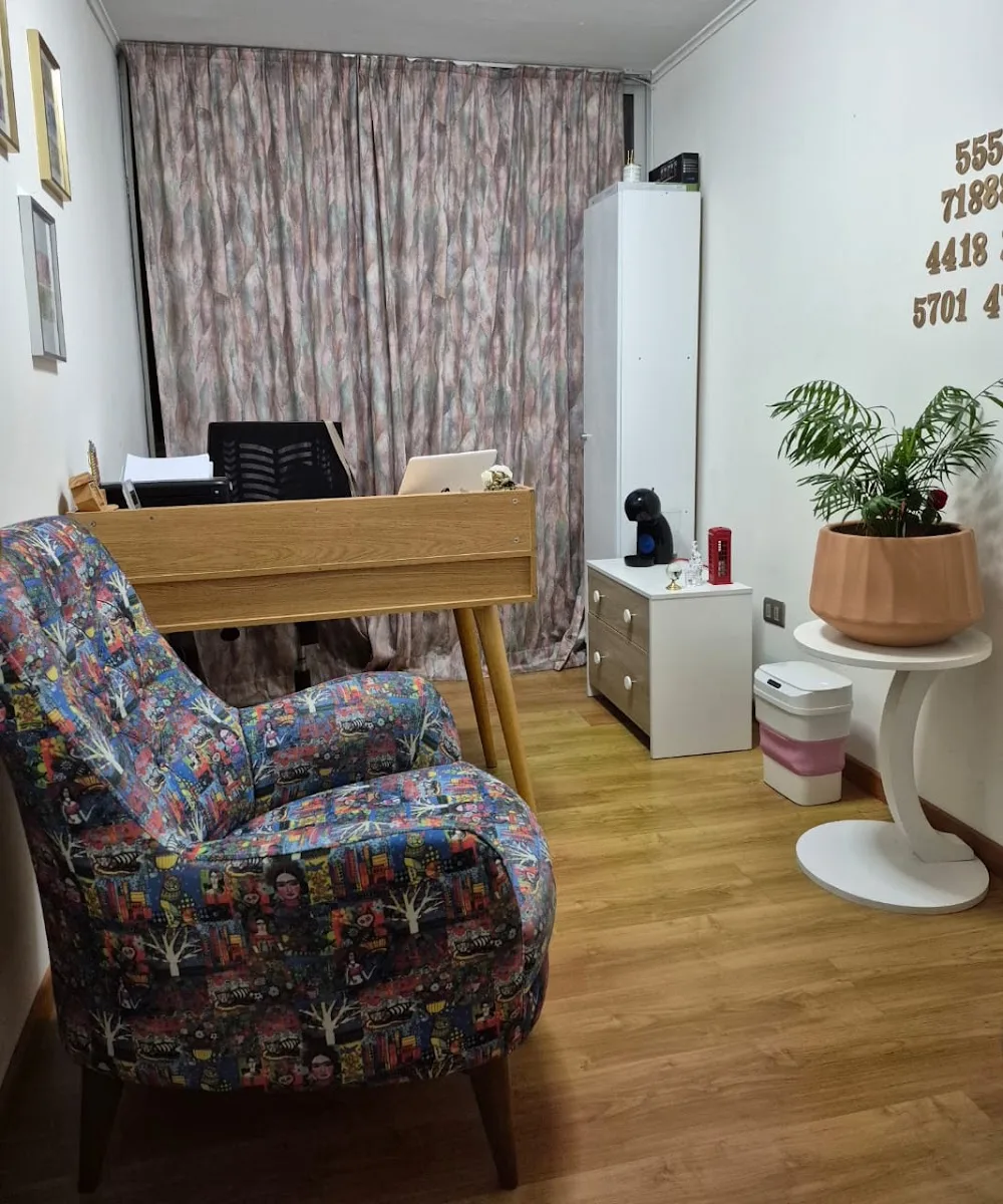 Oficina de Jacqueline Moraga: escritorio de madera, sillón estampado y plantas