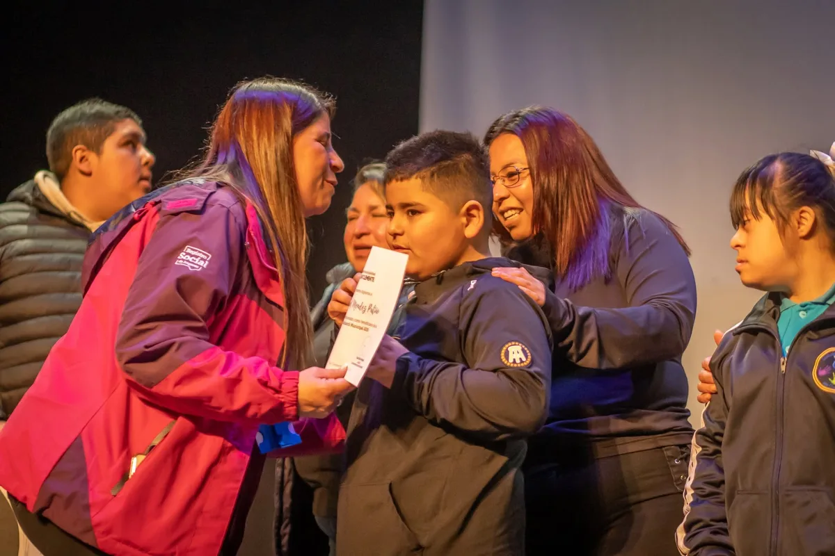 Familia de San Clemente recibiendo un computador de la Beca TIC JUNAEB