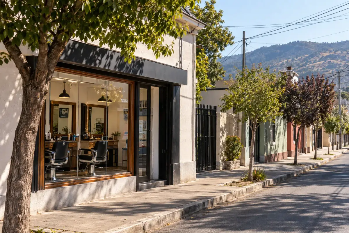 Fachada de la barbería DamianStyle en una calle arbolada de Pelarco