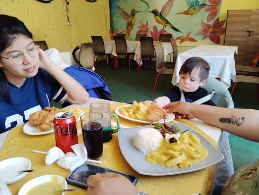 Familia almorzando frente al mural del restaurante
