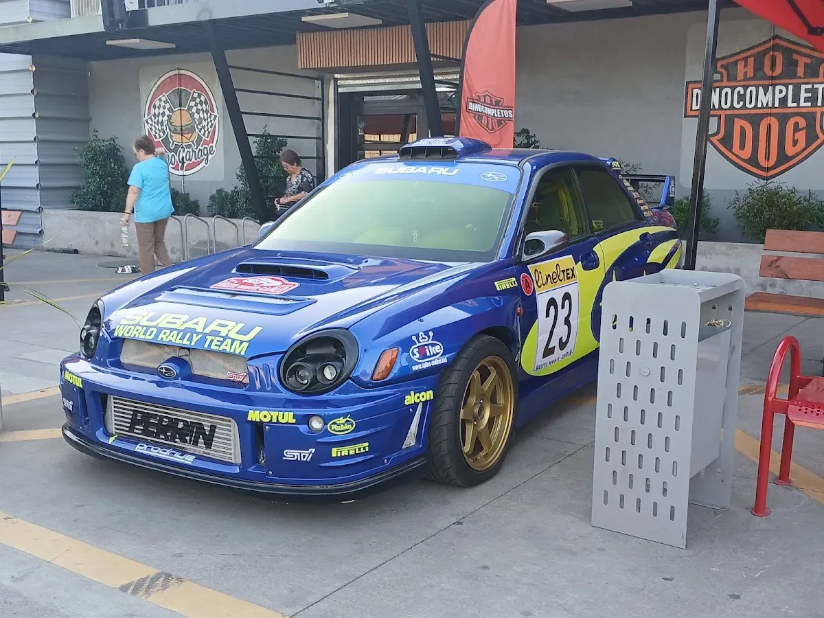 Auto de rally azul estacionado frente al local de Dinocompletos