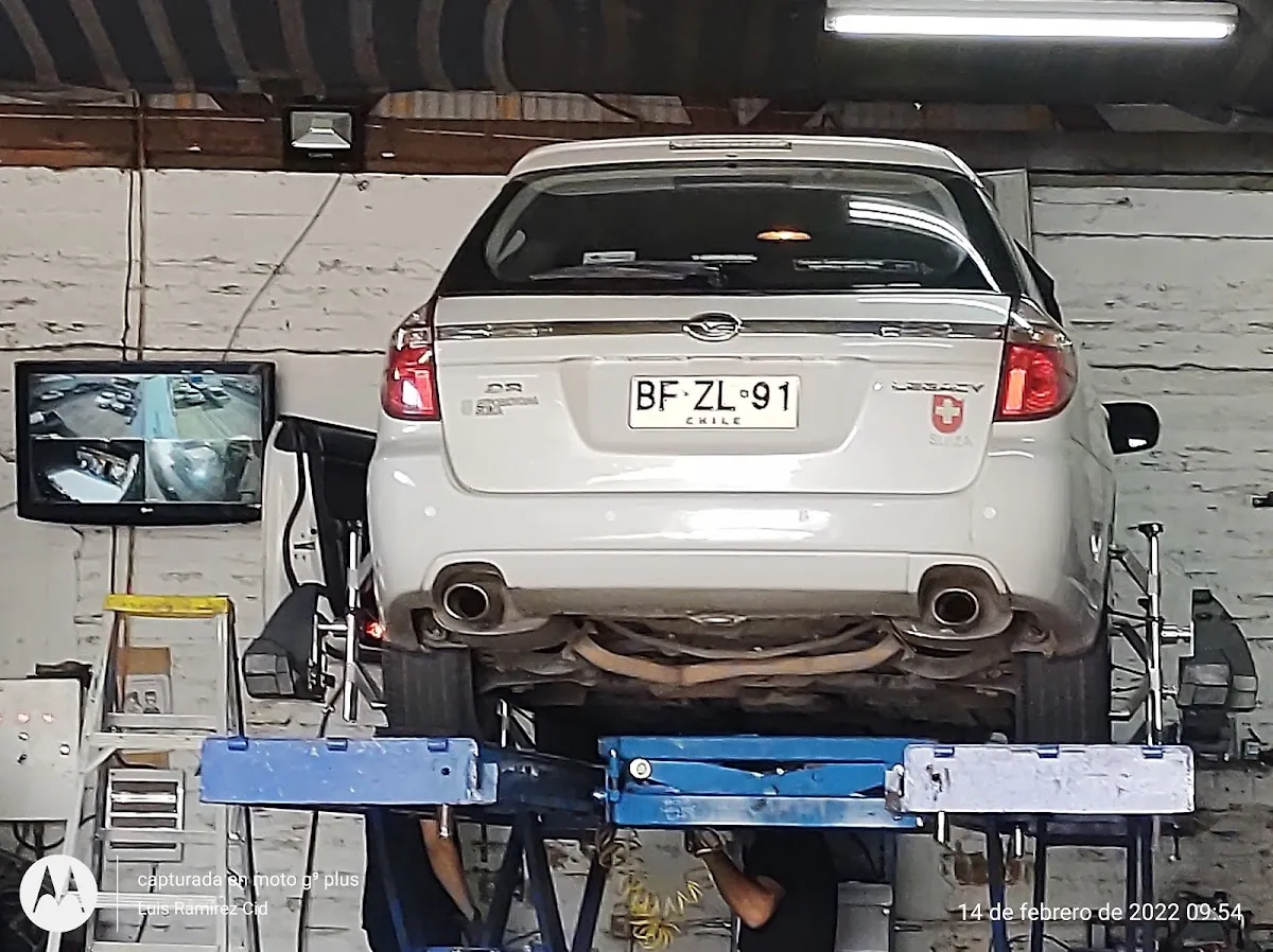 Vista inferior de un auto en el elevador mostrando la suspensión y el tren delantero