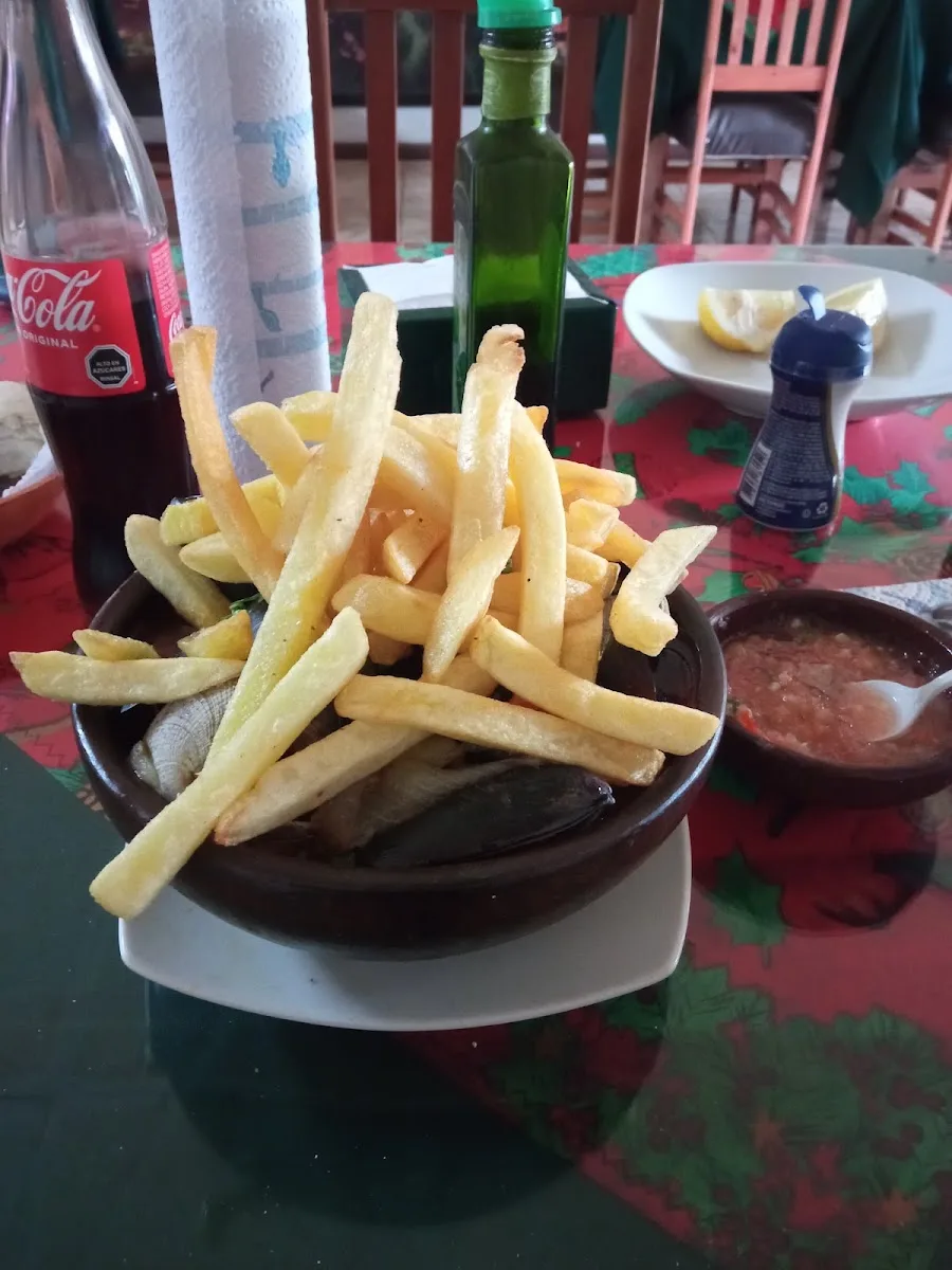 Pollo Mariscal: papas doradas sobre salsa de mariscos, plato insignia de El Bigote