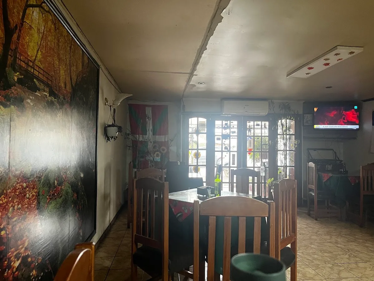 Salón interior de El Bigote con mural y mesas