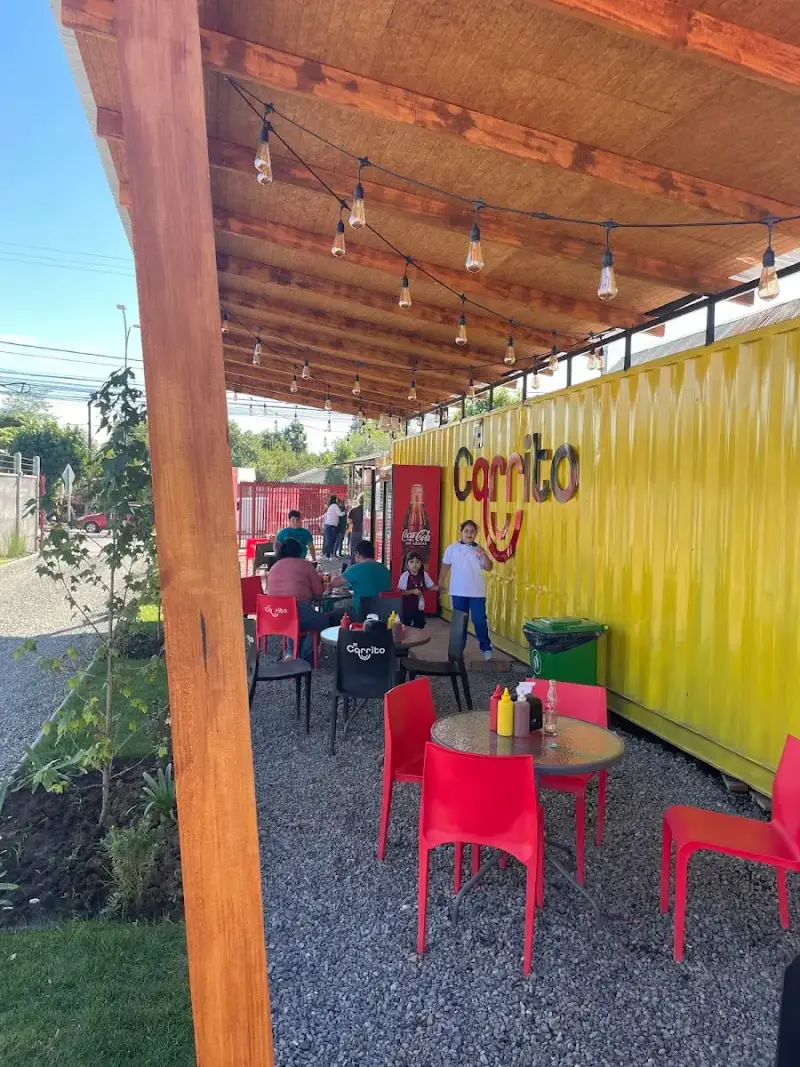 Terraza de El Carrito en Parral: container amarillo con mesas rojas