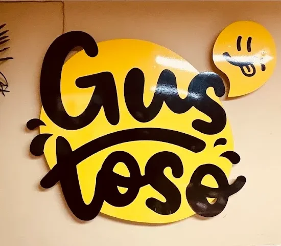 Logo Gustoso pintado en la pared del local