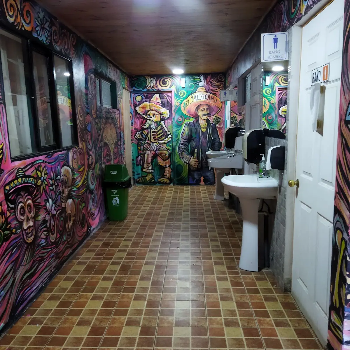 Pasillo de El Mexicano cubierto de murales coloridos con figuras mexicanas