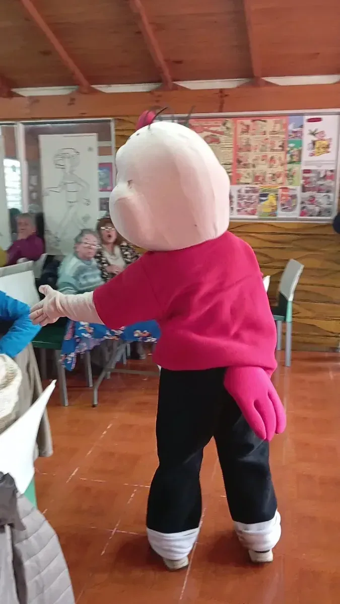 El personaje de Condorito visitando el salón del restaurante entre mesas y comensales