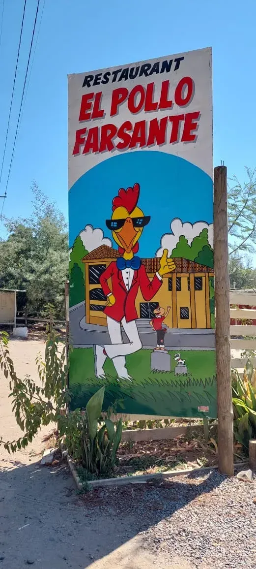 El tótem de El Pollo Farsante: el pollo con chaqueta roja, corbatín azul y lentes oscuros haciendo la seña de pulgar arriba
