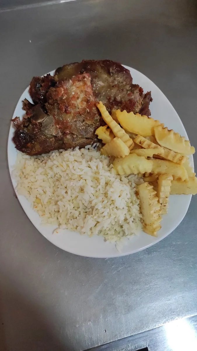 Plato de fondo servido en El Rincón del Sabor con papas y ensalada