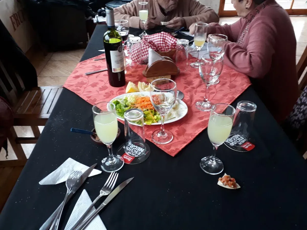 Mesa del restaurante con mantel, plato servido y cubiertos
