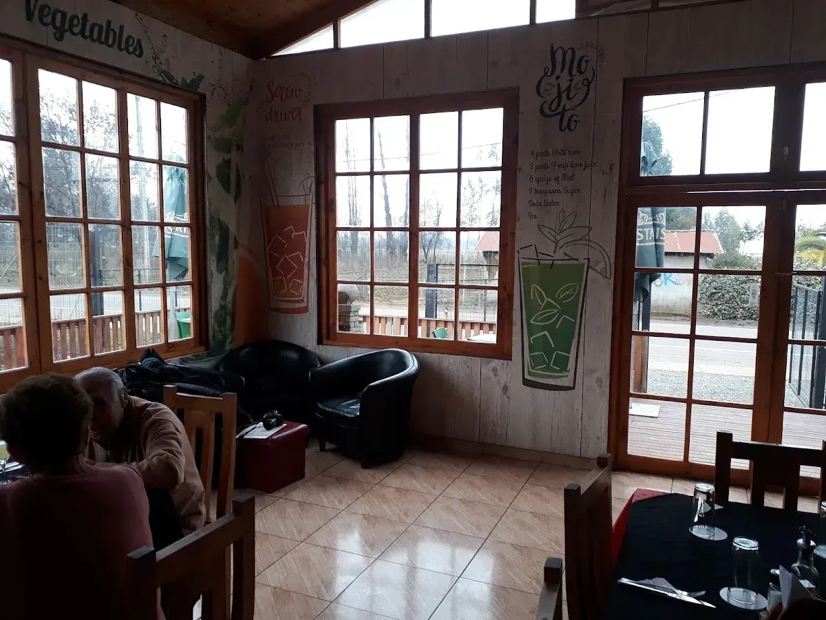 Vista del salón comedor con mesas de madera y sillas tapizadas