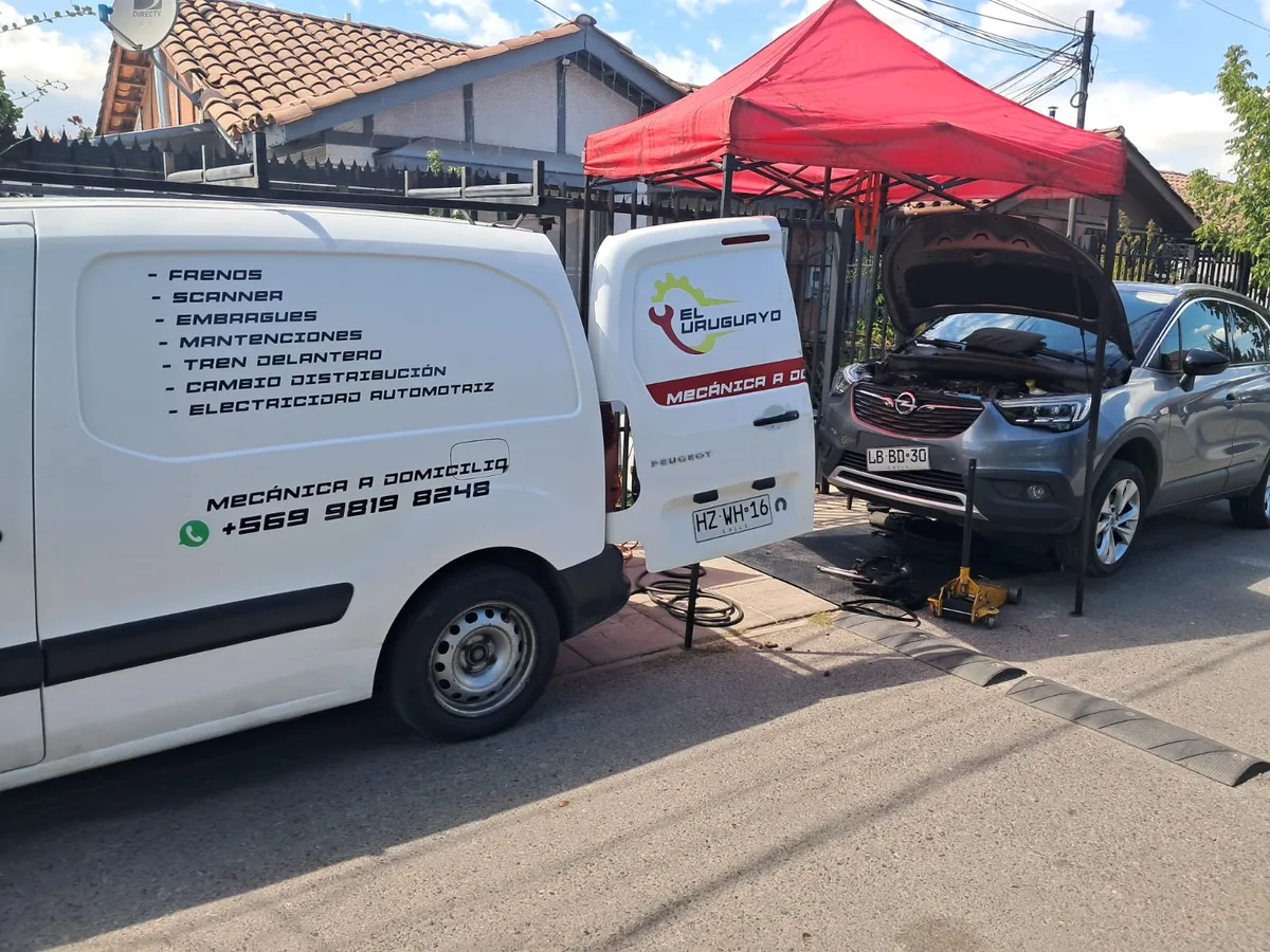 Furgón taller de El Uruguayo con carpa de trabajo atendiendo un auto a domicilio