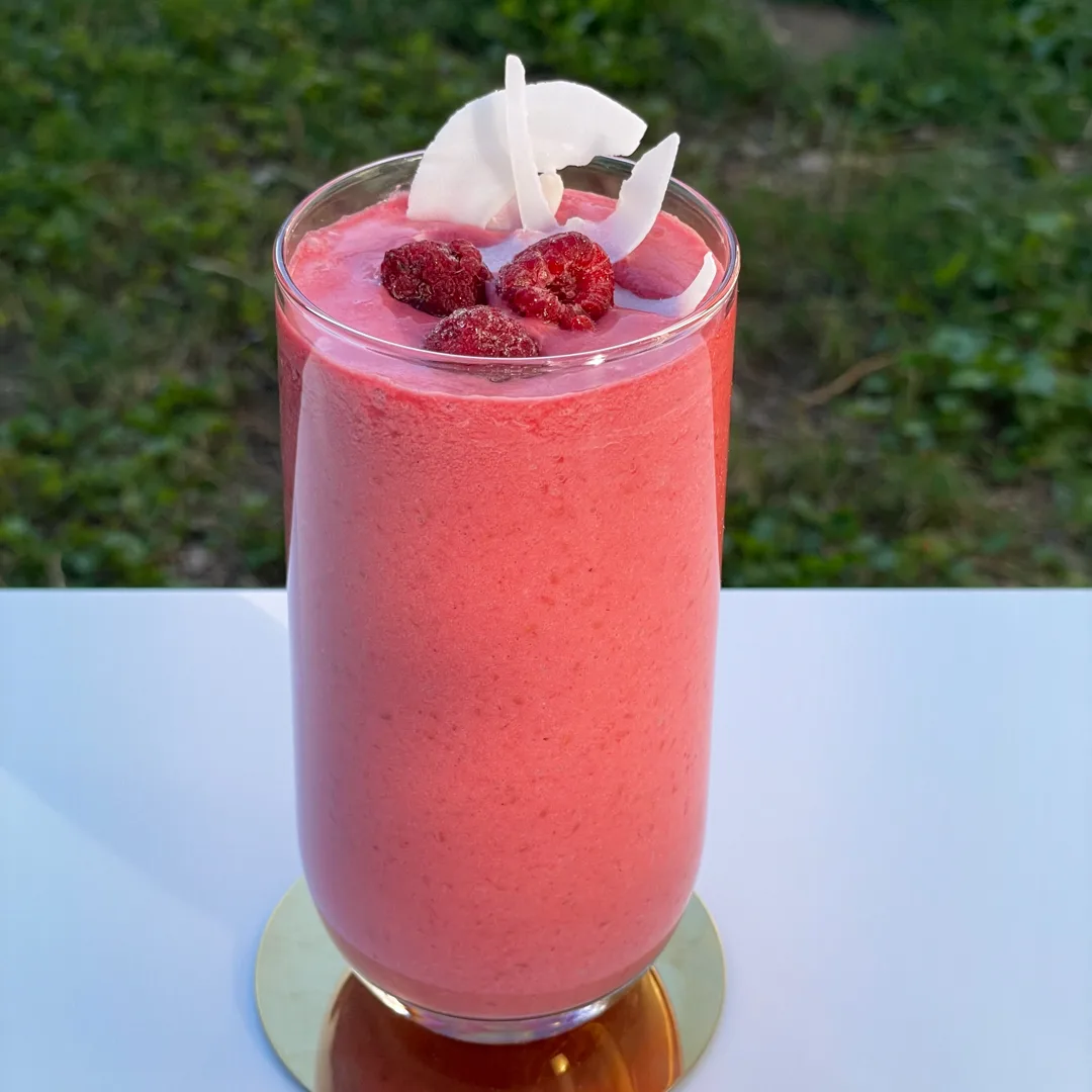 Bebida Frambuesa Colada de Emilia servida en vaso alto con crema