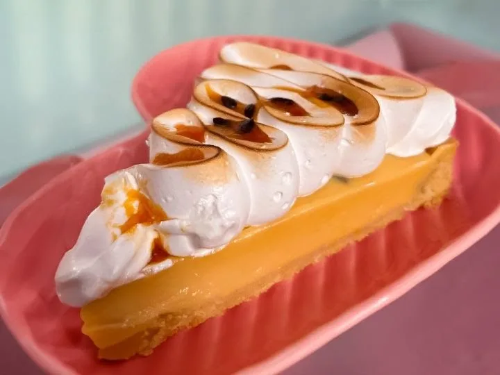 Trozo de pie de limón sobre plato rosado de Emilia Coffee & Cake