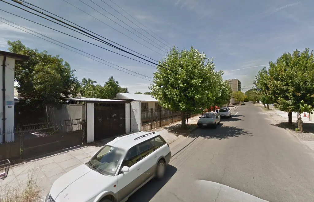 Calle del barrio norte de Talca con líneas eléctricas sobre la vereda