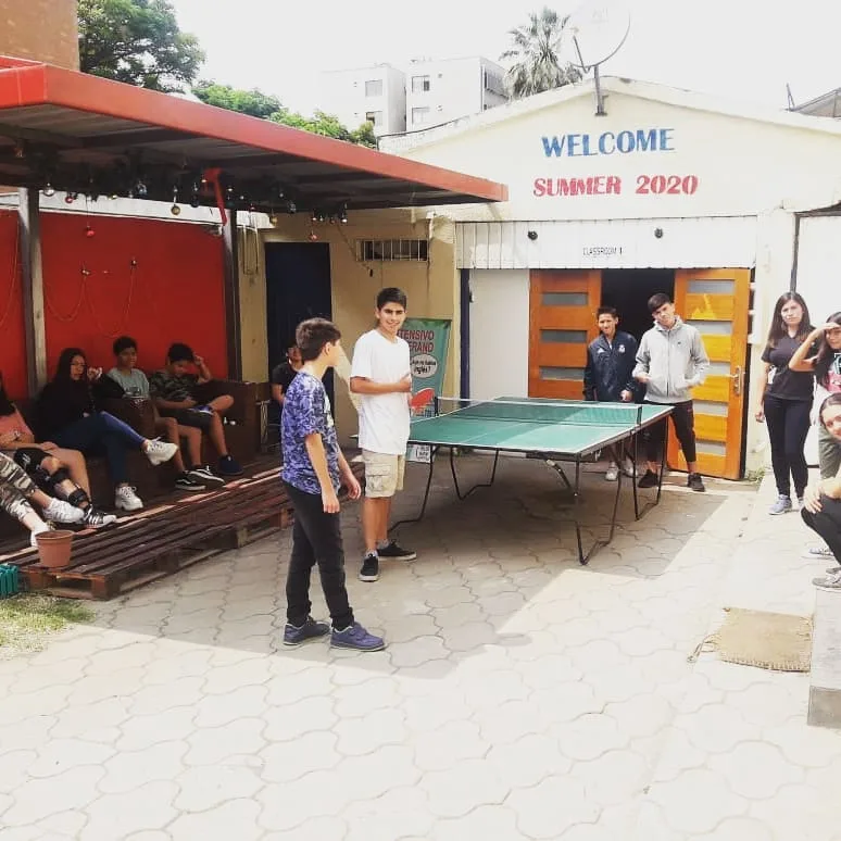 Patio del instituto con alumnos jugando ping pong junto a la sala Classroom 1