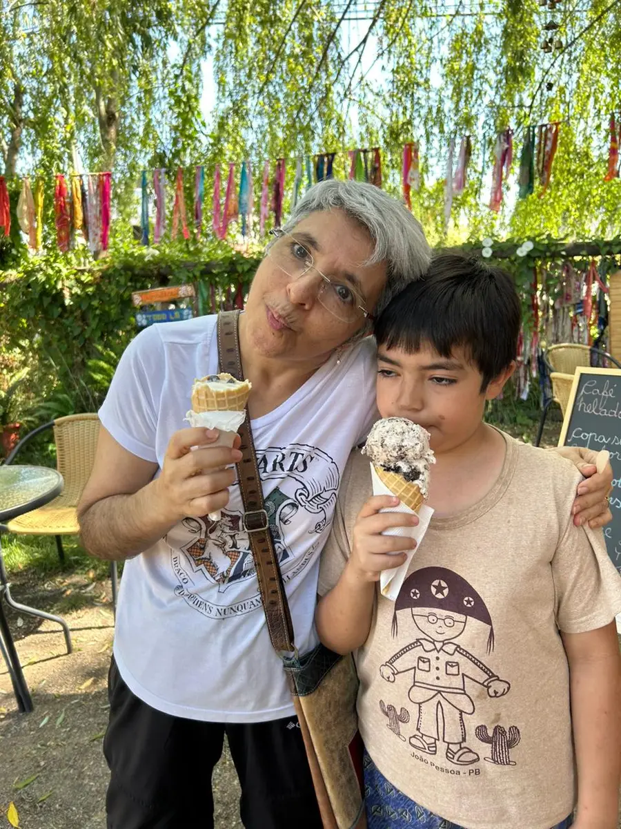 La dueña de Espacio Dominga con un niño, ambos con conos de helado bajo los sauces
