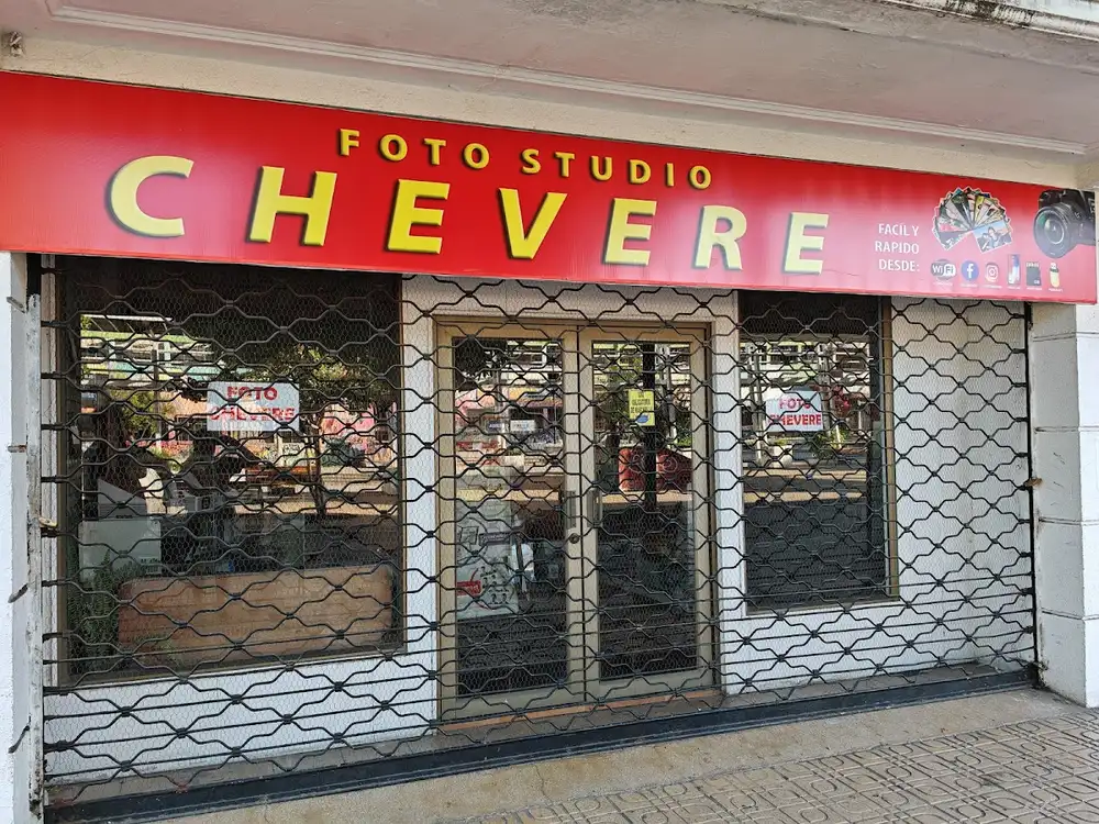 Letrero rojo nuevo del Foto Studio Chevere sobre la reja del local