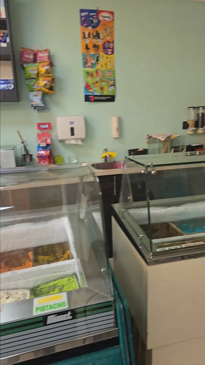 Interior de la heladería con mesas y sillas teal