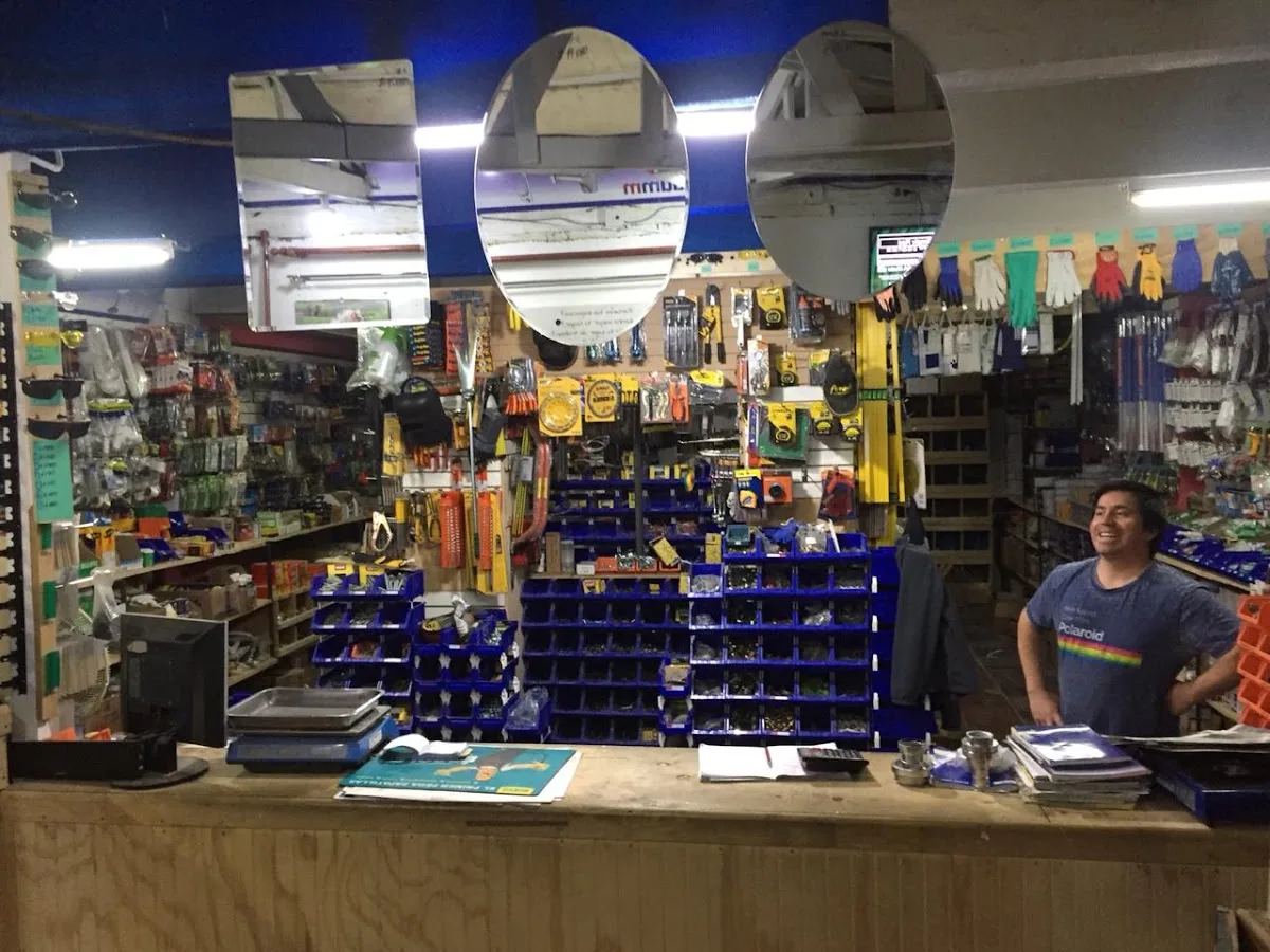 Mostrador de Ferretería Facón con repisas de tuercas, guantes y herramientas colgadas detrás
