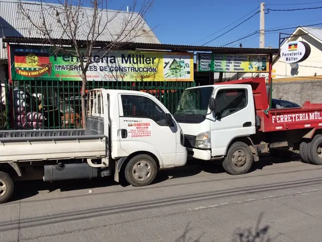 Camión rojo con letrero Ferretería Müller Áridos cargado para despacho