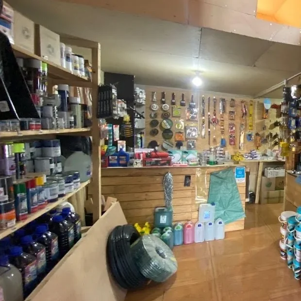 Repisas de la ferretería con latas de pintura y accesorios
