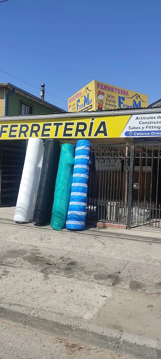 Letrero de la esquina de FerriMas: rótulo amarillo con el vaquero y el anuncio de gasfitería, electricidad y herramientas