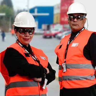 Dos guardias de First Security con chaleco naranja y casco en terreno