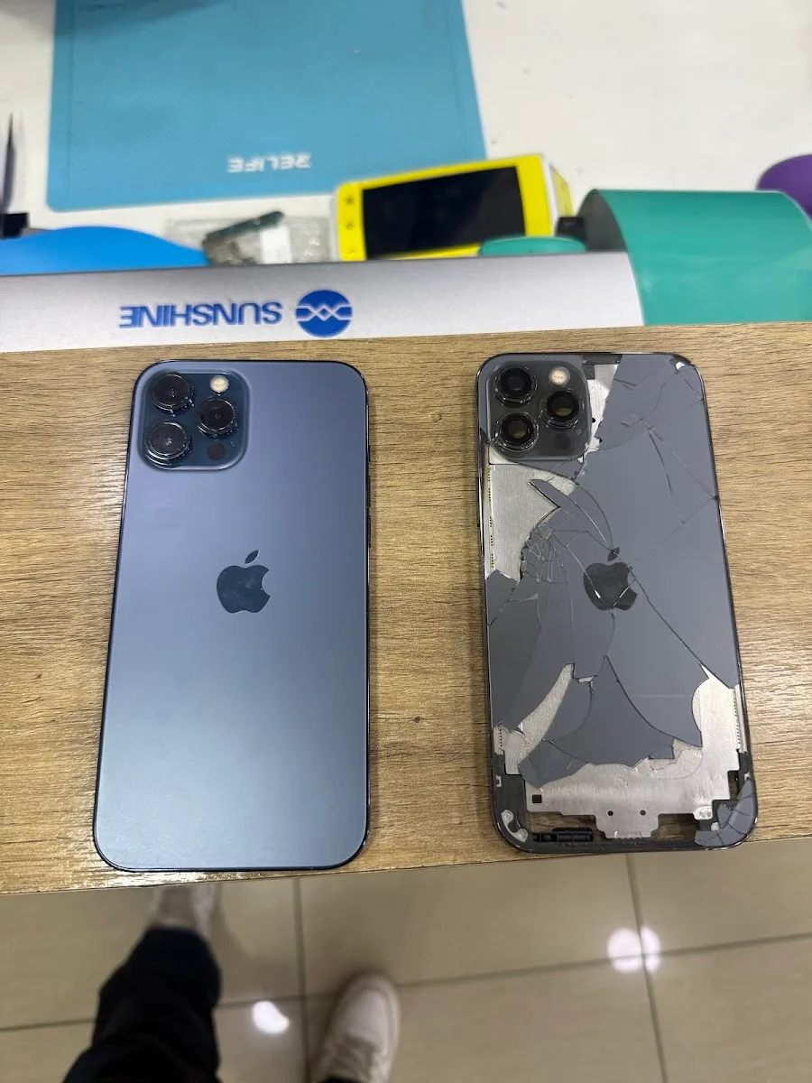 Dos iPhone sobre el mesón de Fix Store, uno con tapa trasera quebrada y otro reparado