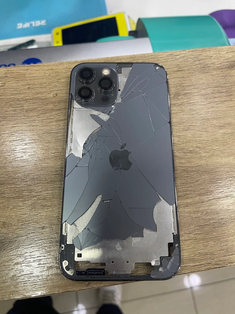 iPhone con tapa trasera quebrada esperando reparación en Fix Store