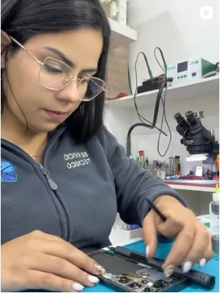 Técnica de Fix Store reparando un celular abierto en el mesón