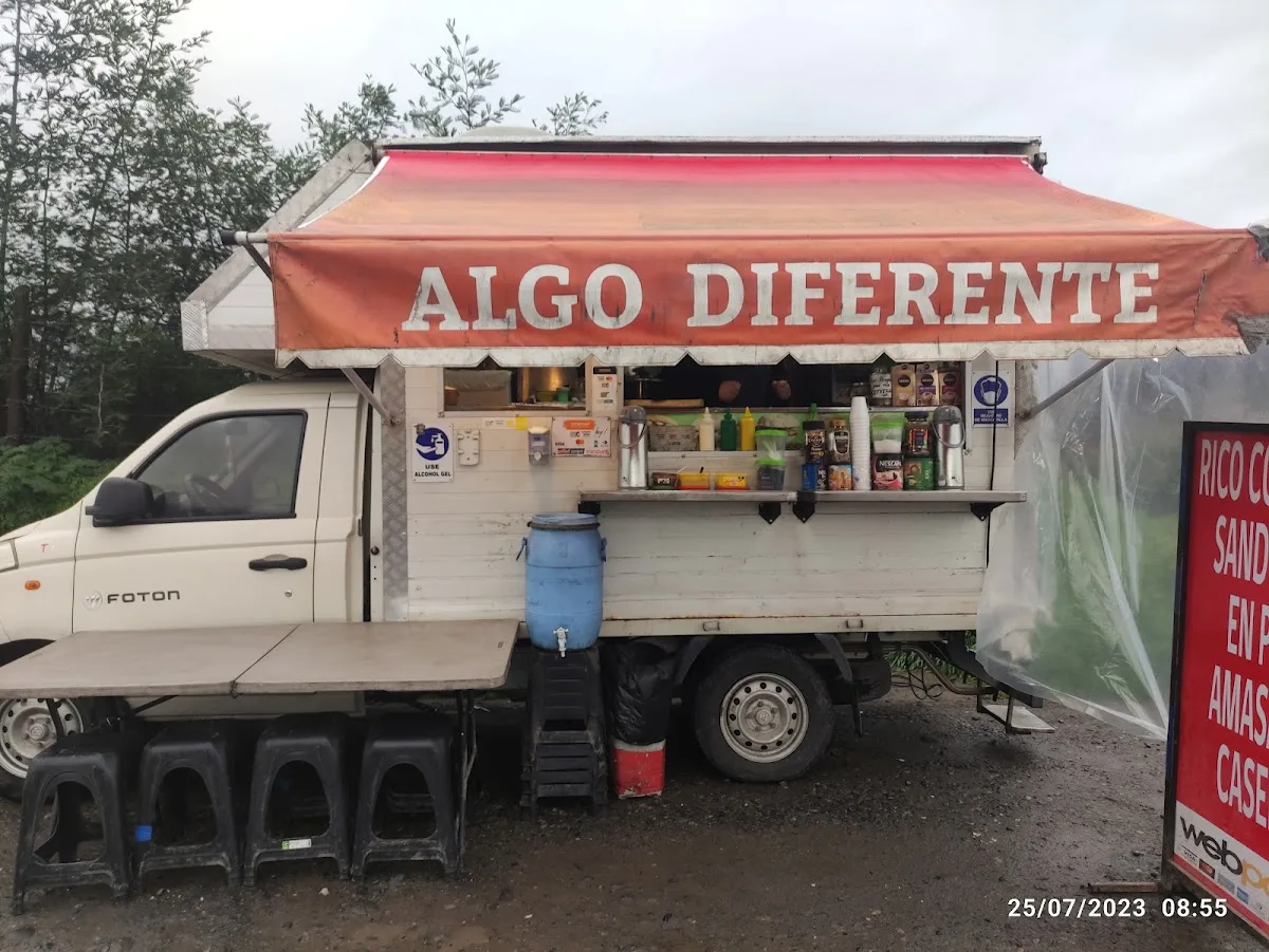 El food truck blanco de Algo Diferente con toldo naranjo y banquitos al frente