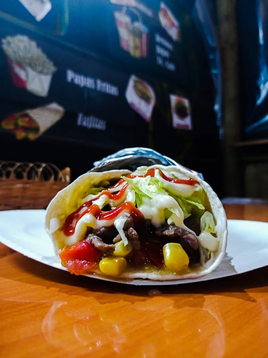 Wrap con carne, choclo y salsas frente a la carta del food truck