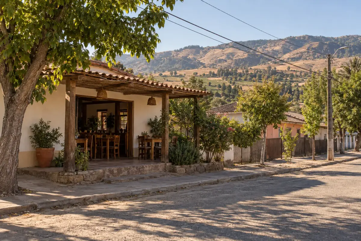 Terraza de FORASTERO con mesas de madera y vista a los cerros de Pencahue