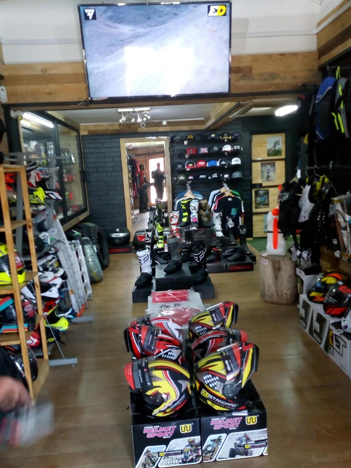 Interior de la tienda con ropa de motocross colgada en percher