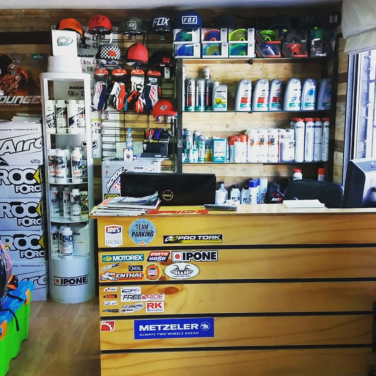 Mesón de la tienda con lubricantes Ipone y calcomanías de marcas de motos