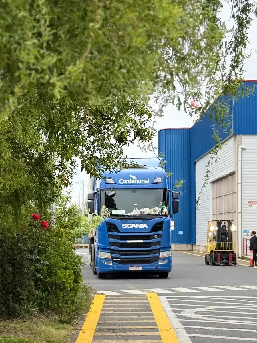 Camión Scania entrando a la planta del grupo entre árboles