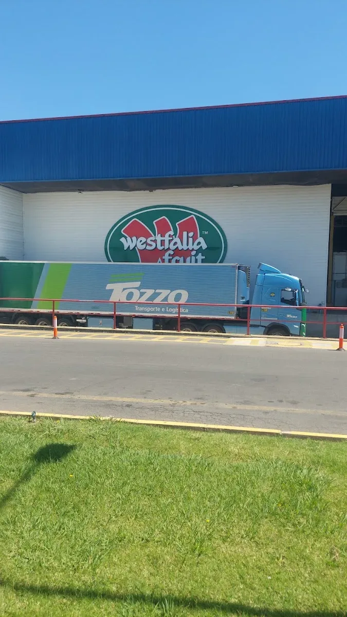 Camión en el patio de la planta con el logo de Westfalia Fruit en la fachada