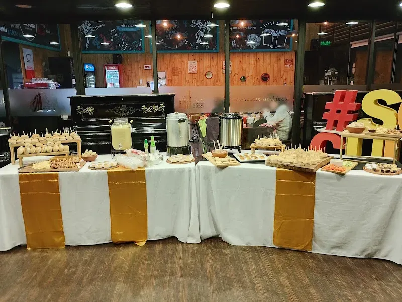 Salón de evento con mesas vestidas de mantel blanco y runner dorado montadas por Gacitúa