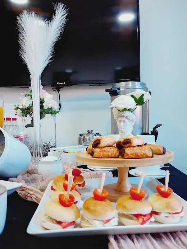 Mesa de buffet decorada con plumas de pampa y bandejas de postres